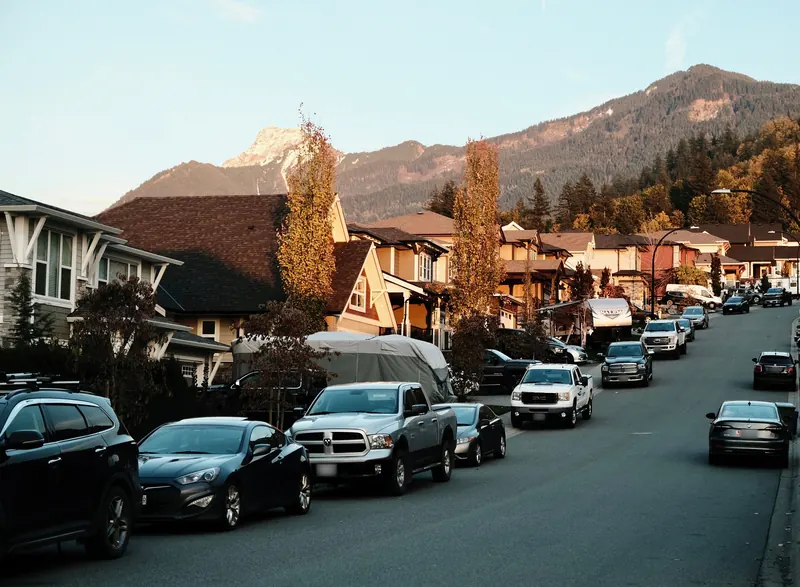 A residential street of family homes below the mountains