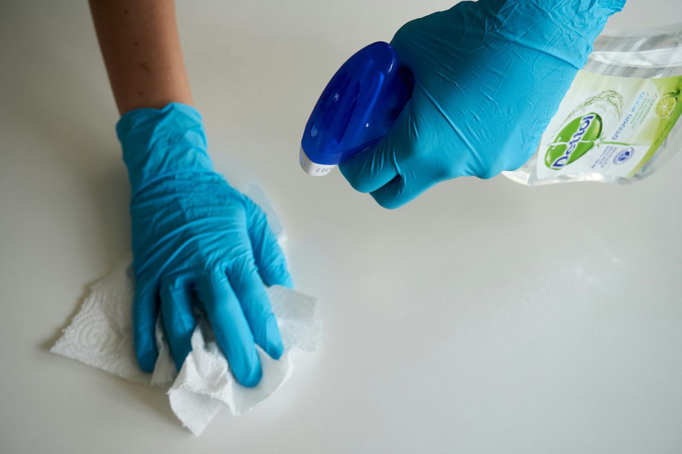A gloved hand wiping a counter clean